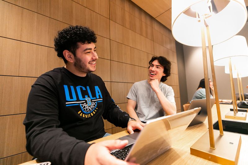 Students sitting at their laptops in a modern reading room
