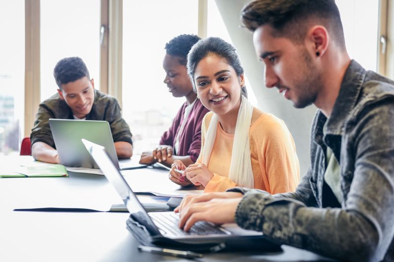 Students studying together at shared laptops